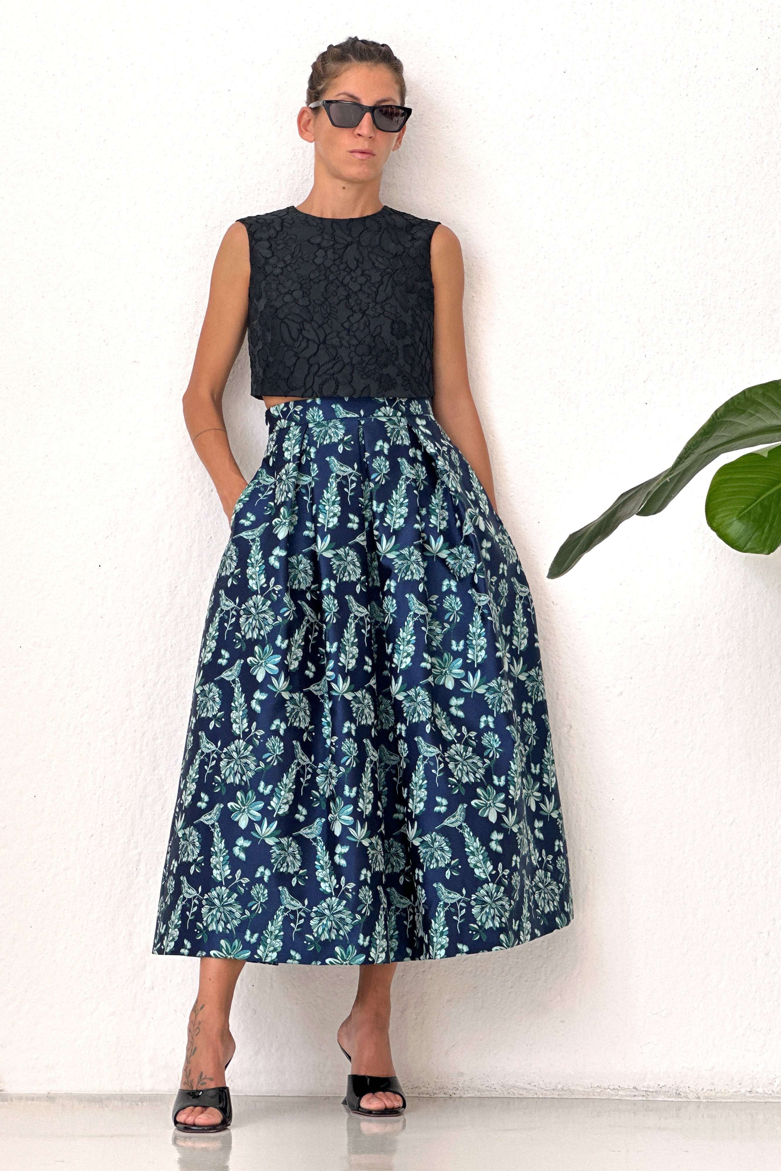 Woman wearing Gonna Lurex Bird Blu pleated jacquard skirt with floral and bird pattern and lurex thread accents