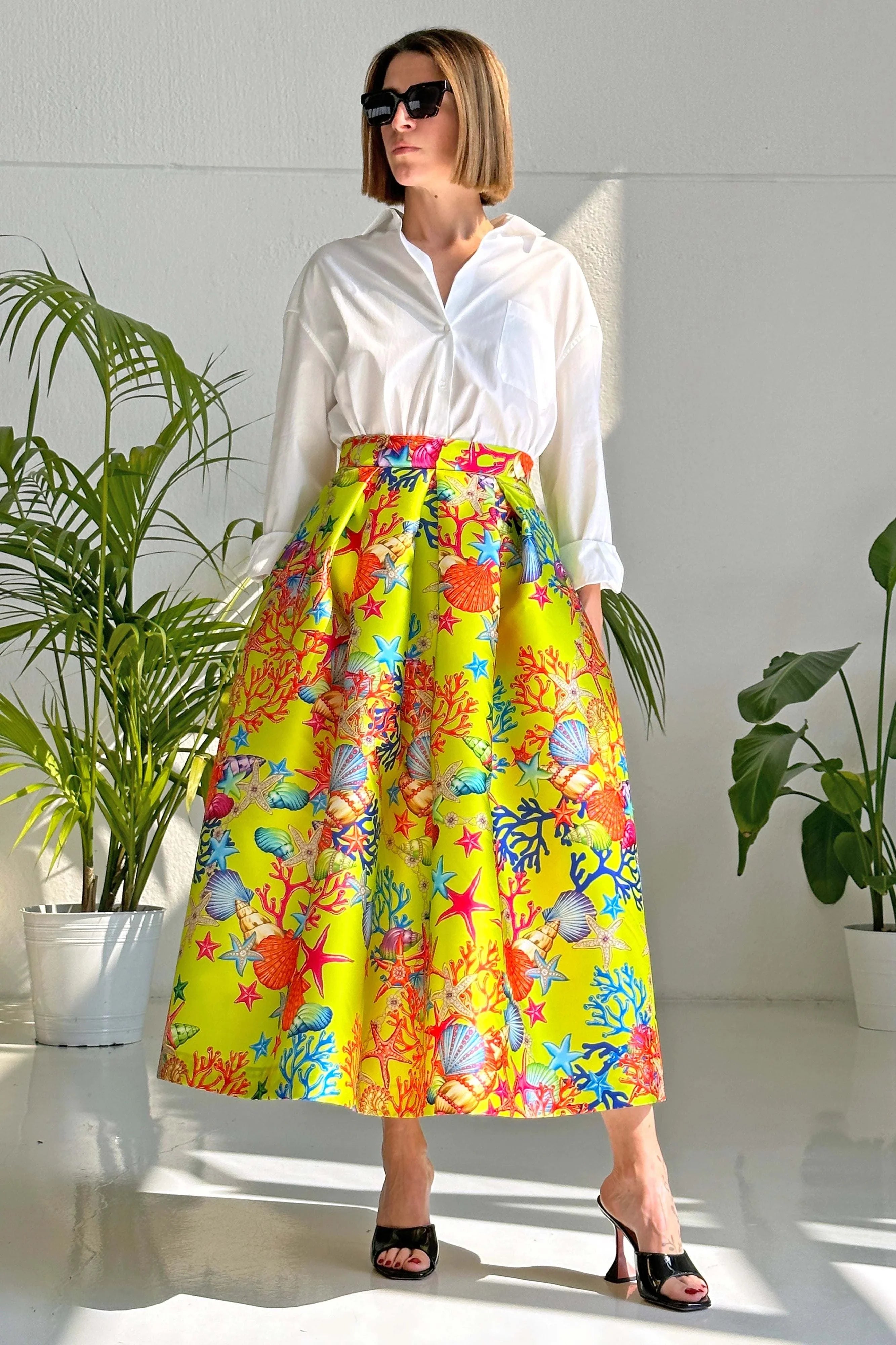 Woman wearing Gonna Reef Acid midi skirt with colorful mikado fabric reef print and high waist