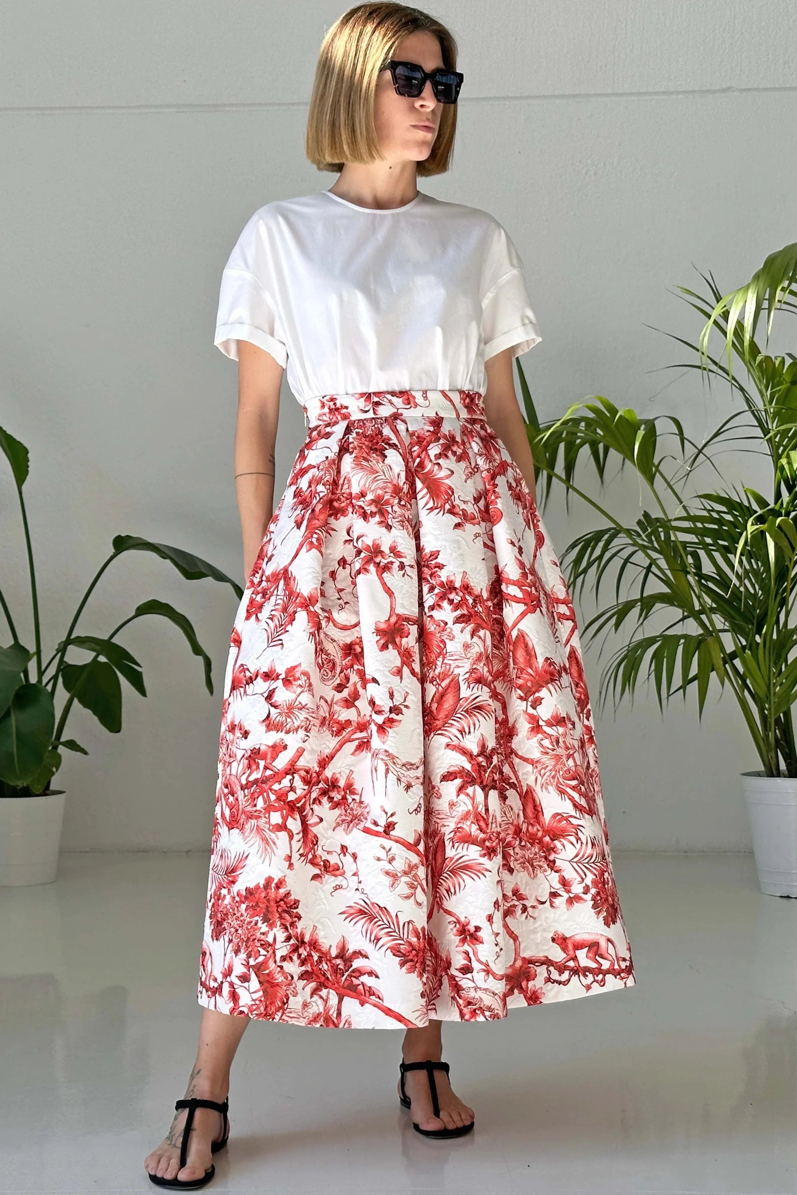Woman wearing Gonna midi Ethos red coral printed matelassé midi skirt with white top and black sandals