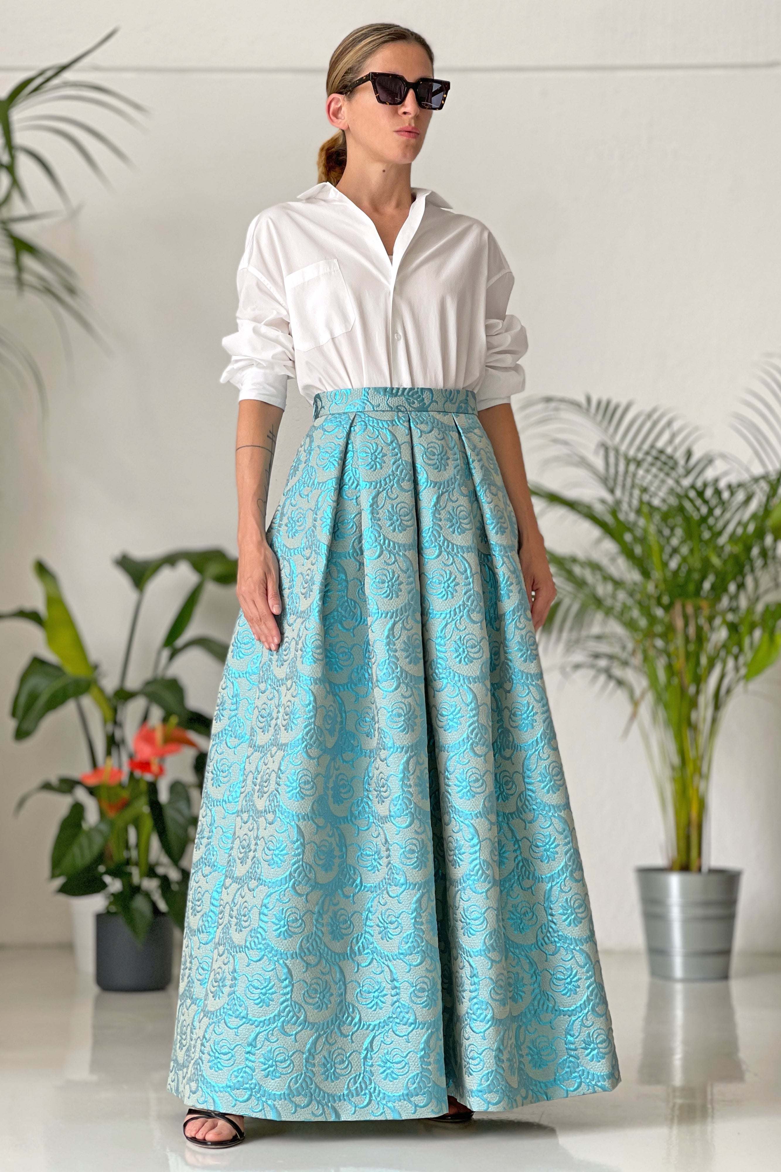 Donna che indossa gonna lunga Lurex azzurra ampia a vita alta in tessuto jacquard senza fodera